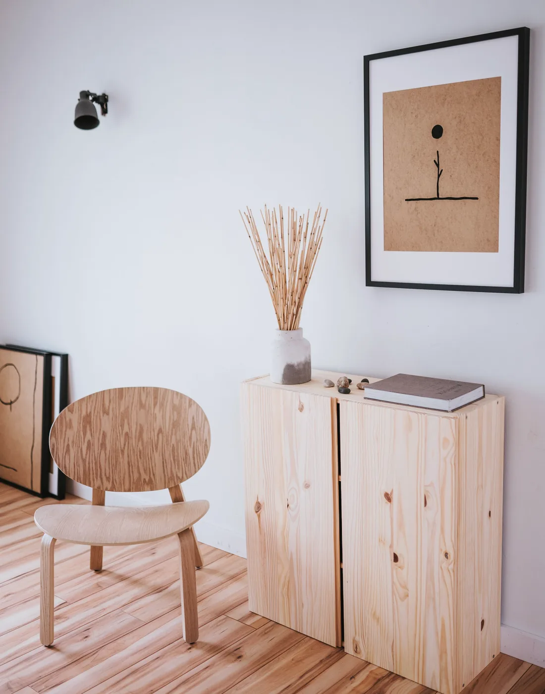 Low ash cabinet in the studio with a woven stool and framed print